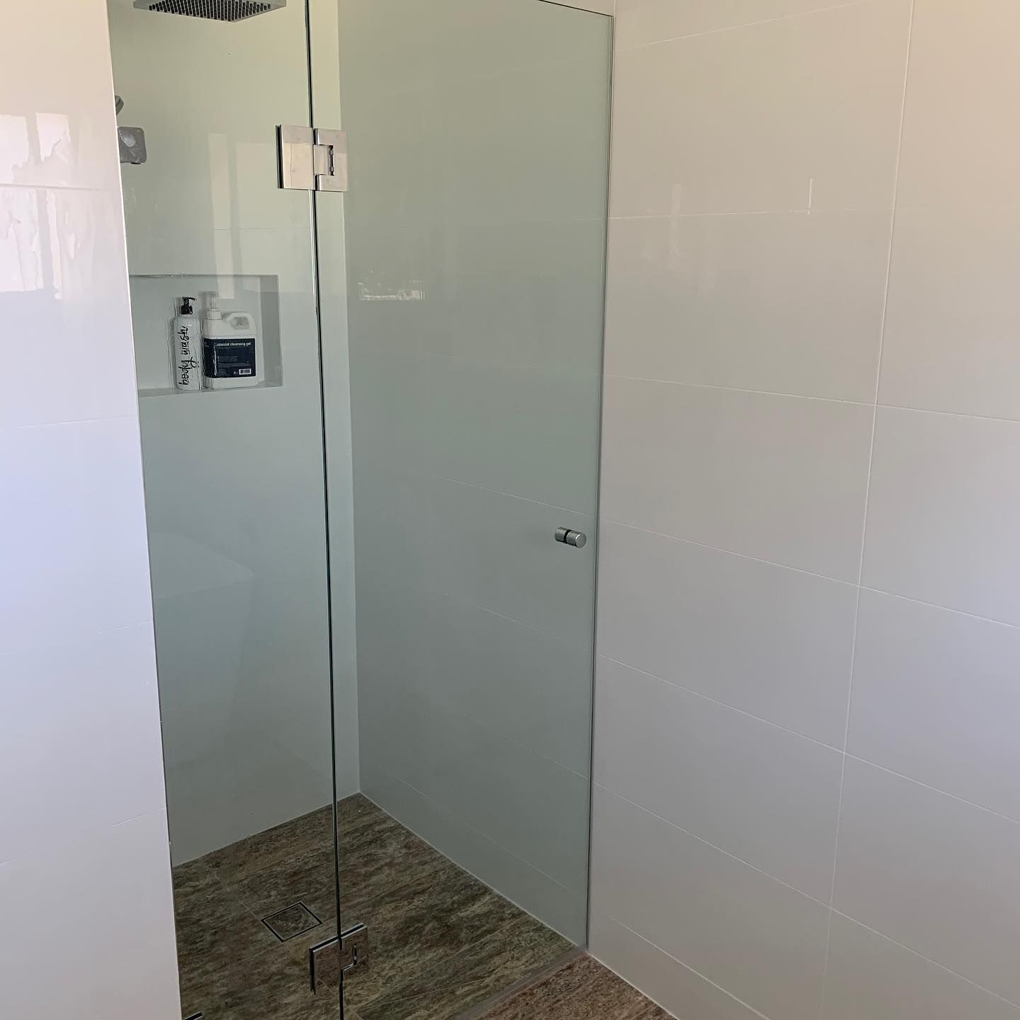 A Bathroom With A Glass Shower Door And A Shower Head — InStyle Shower Screens & Wardrobes in Charmhaven, NSW