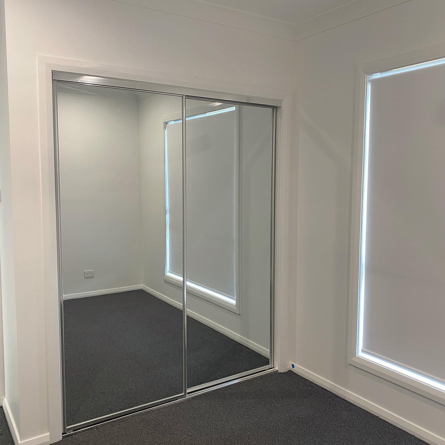 There Is A Large Mirror In The Corner Of The Room — InStyle Shower Screens & Wardrobes in Charmhaven, NSW