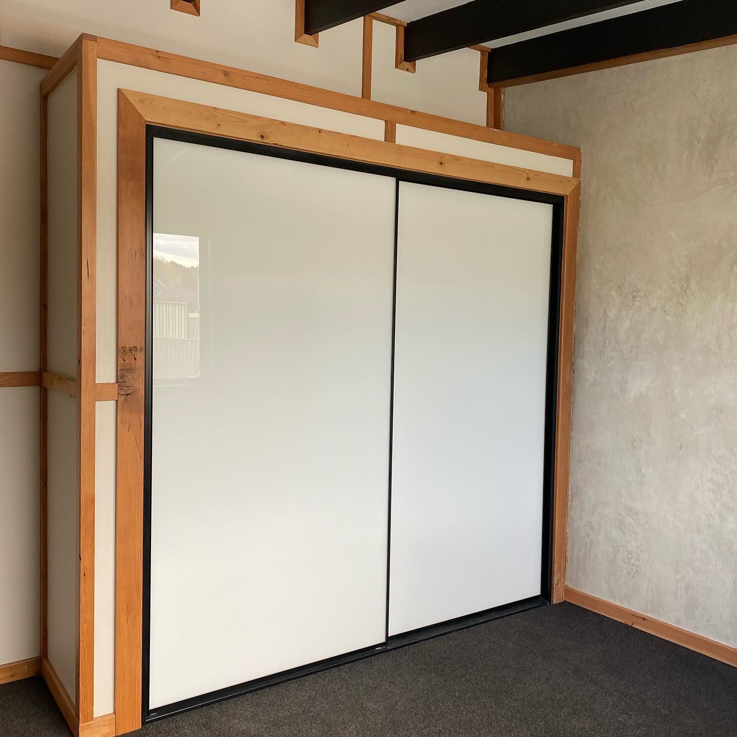 A Room With A Sliding Glass Door And A Wooden Frame — InStyle Shower Screens & Wardrobes in Charmhaven, NSW