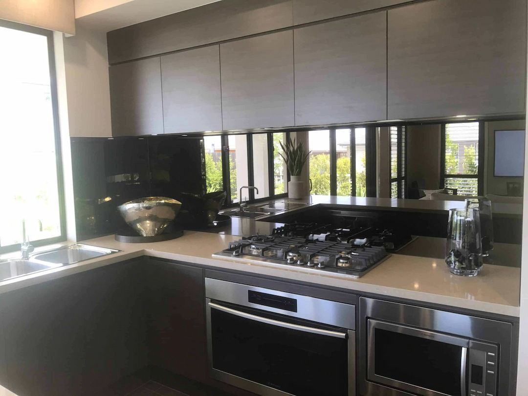 A Kitchen With Stainless Steel Appliances And A Stove Top Oven — InStyle Shower Screens & Wardrobes in Charmhaven, NSW