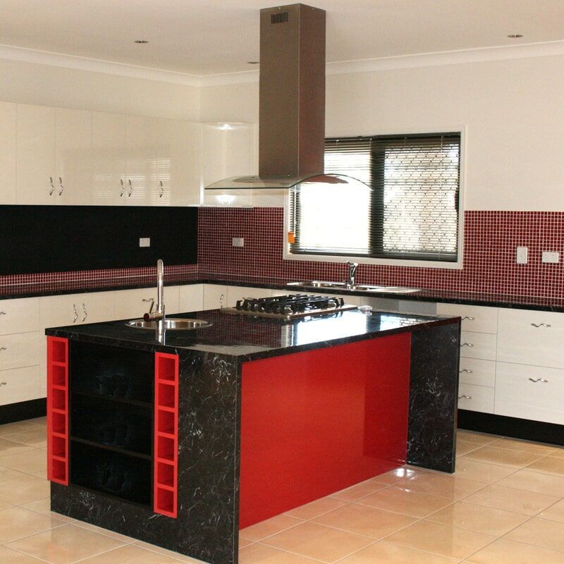 A Kitchen with Black Cabinets and A Red Island — Leader Constructions in Cranbrook, QLD