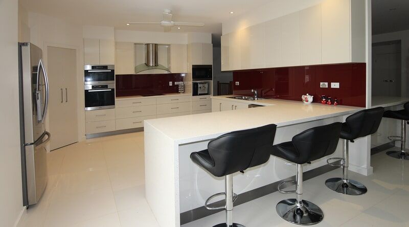 A Kitchen with White Cabinets and Black Bar Stools — Leader Constructions in Cranbrook, QLD