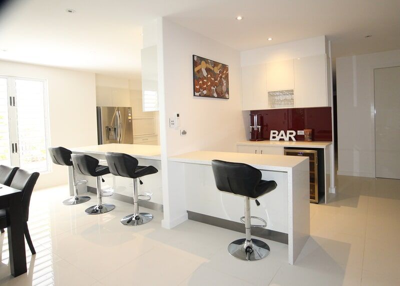 A Big Kitchen with A Bar and Stools in It — Leader Constructions in Cranbrook, QLD