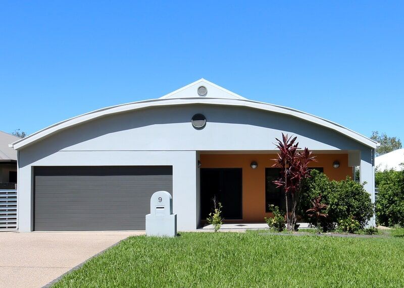 A House with A Curved Roof and Two Garage Doors — Leader Constructions in Cranbrook, QLD
