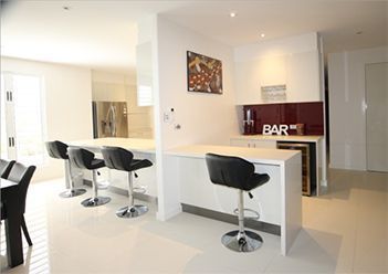 A Beautiful Kitchen with A Bar and Stools in It — Leader Constructions in Cranbrook, QLD