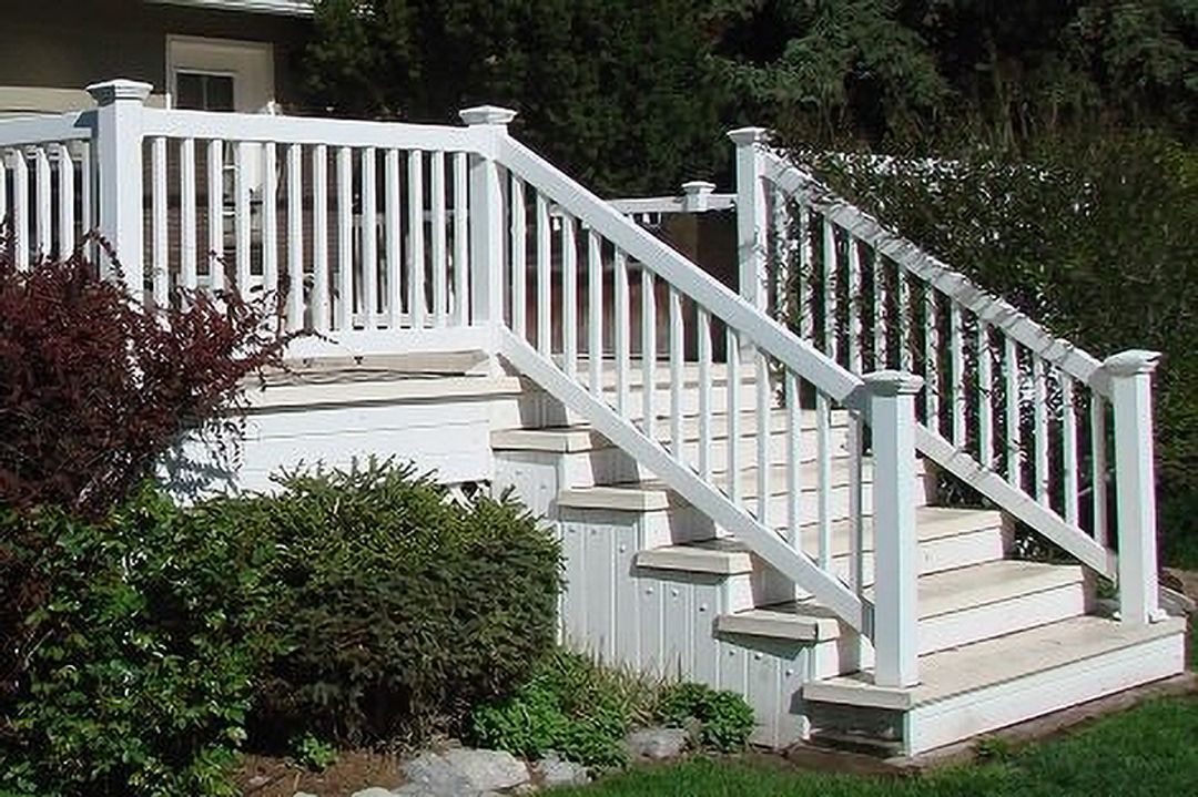 A white deck with stairs and a white railing