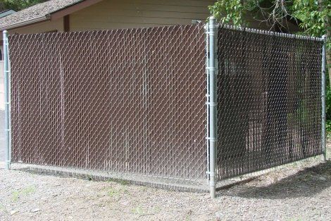 A chain link fence is sitting in front of a house.