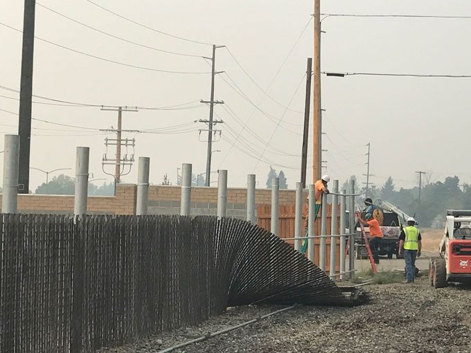 A group of construction workers are working on a fence