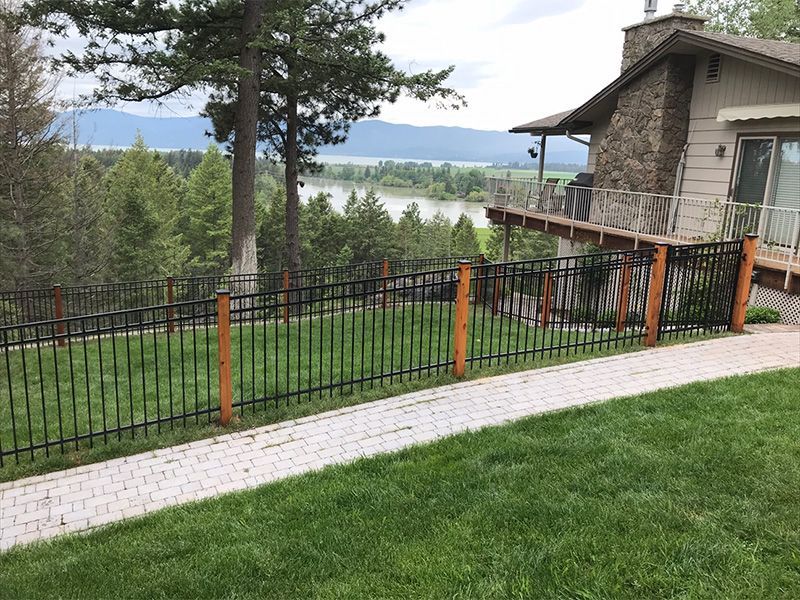 A house with a fence around it and a view of a lake.