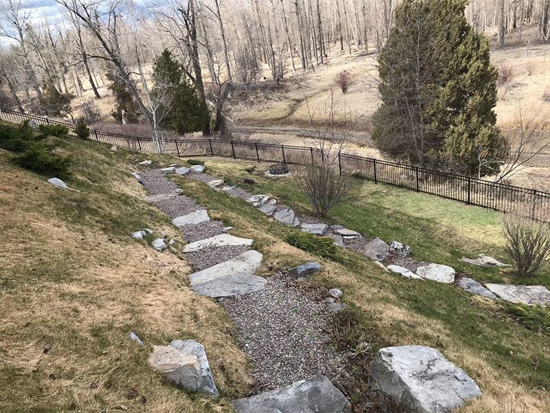A stone path going up a hill with trees in the background.