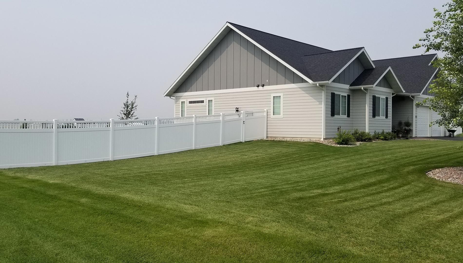 A white house with a white fence in front of it.