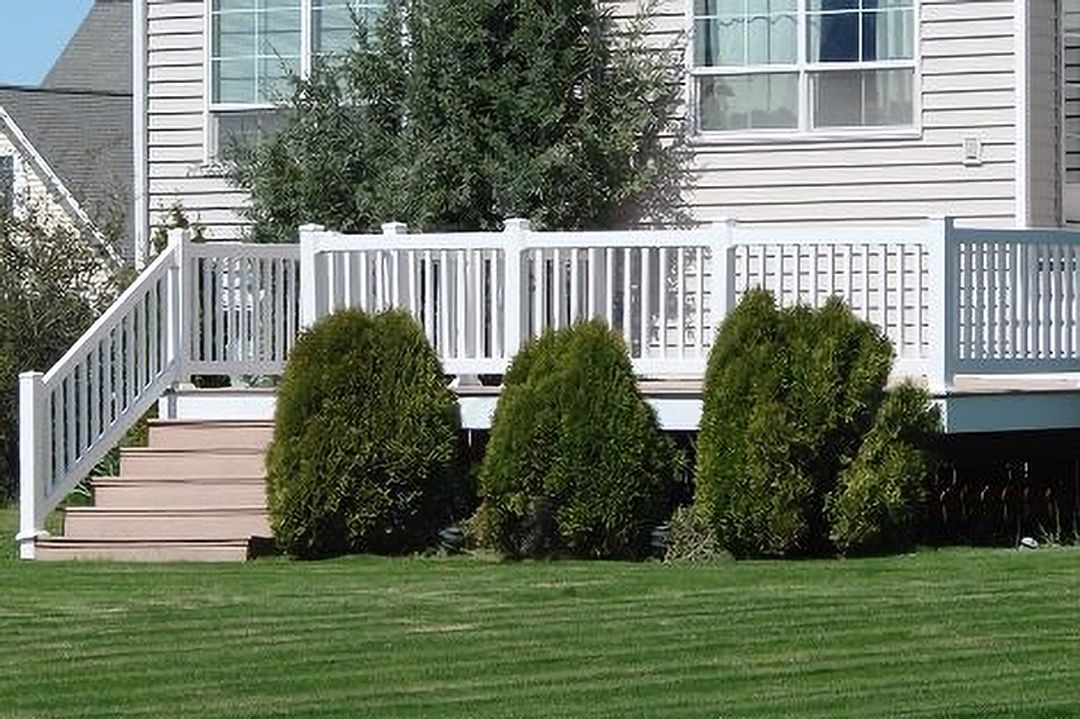 A white house with a white deck and stairs