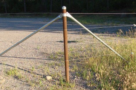A fence post with a metal pole attached to it