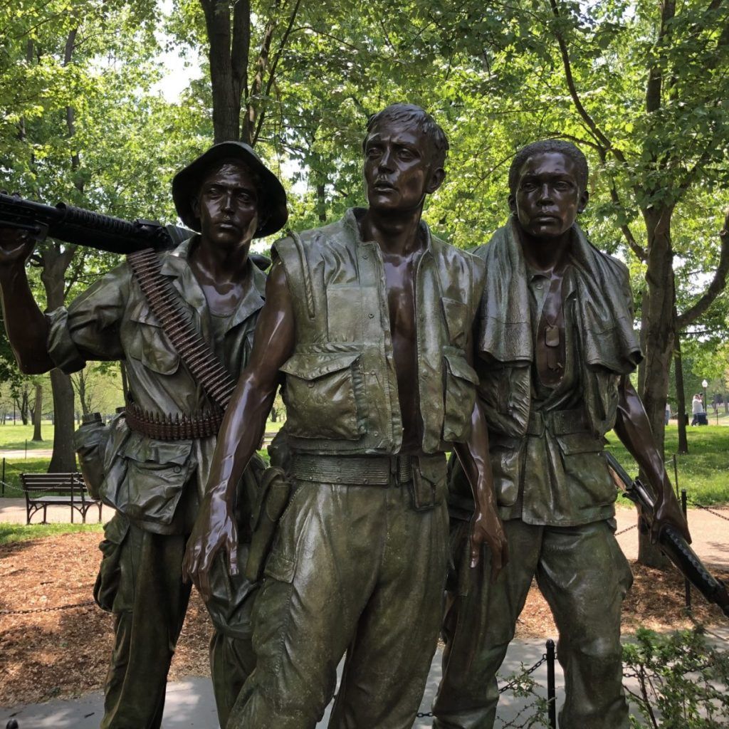 A bronze statue of three soldiers standing next to each other