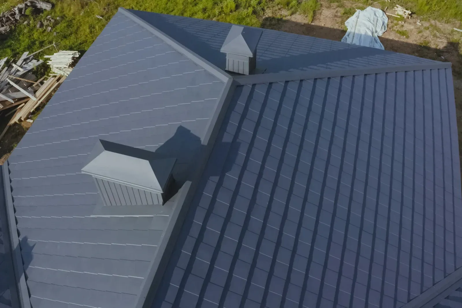 Gray metal roof with two chimneys.