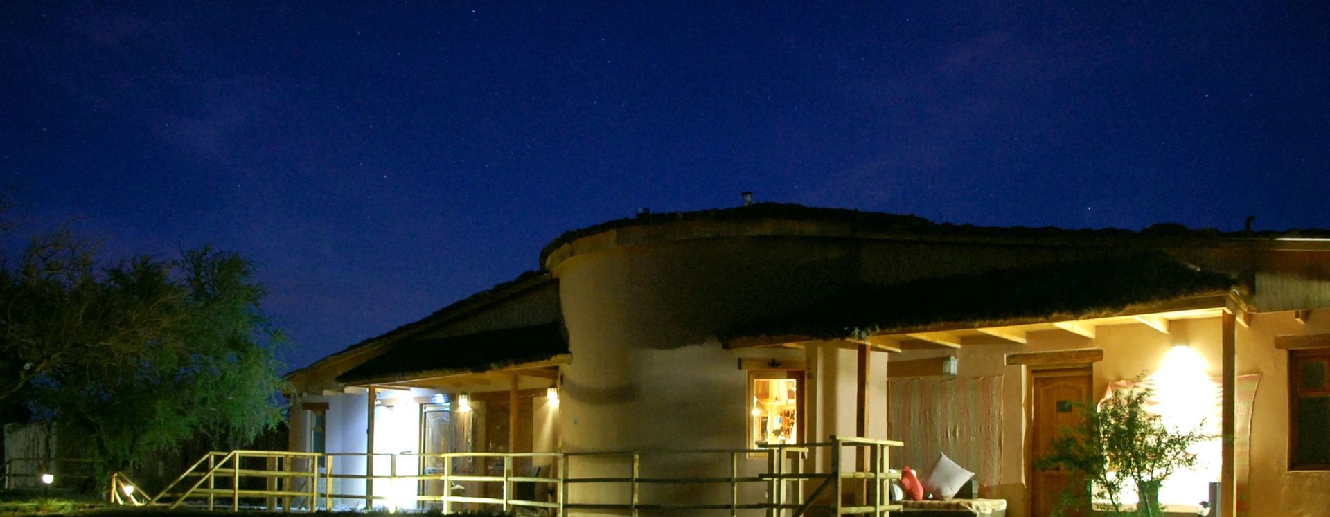 Un edificio al anochecer con un cielo azul oscuro. Las luces exteriores iluminan la estructura.