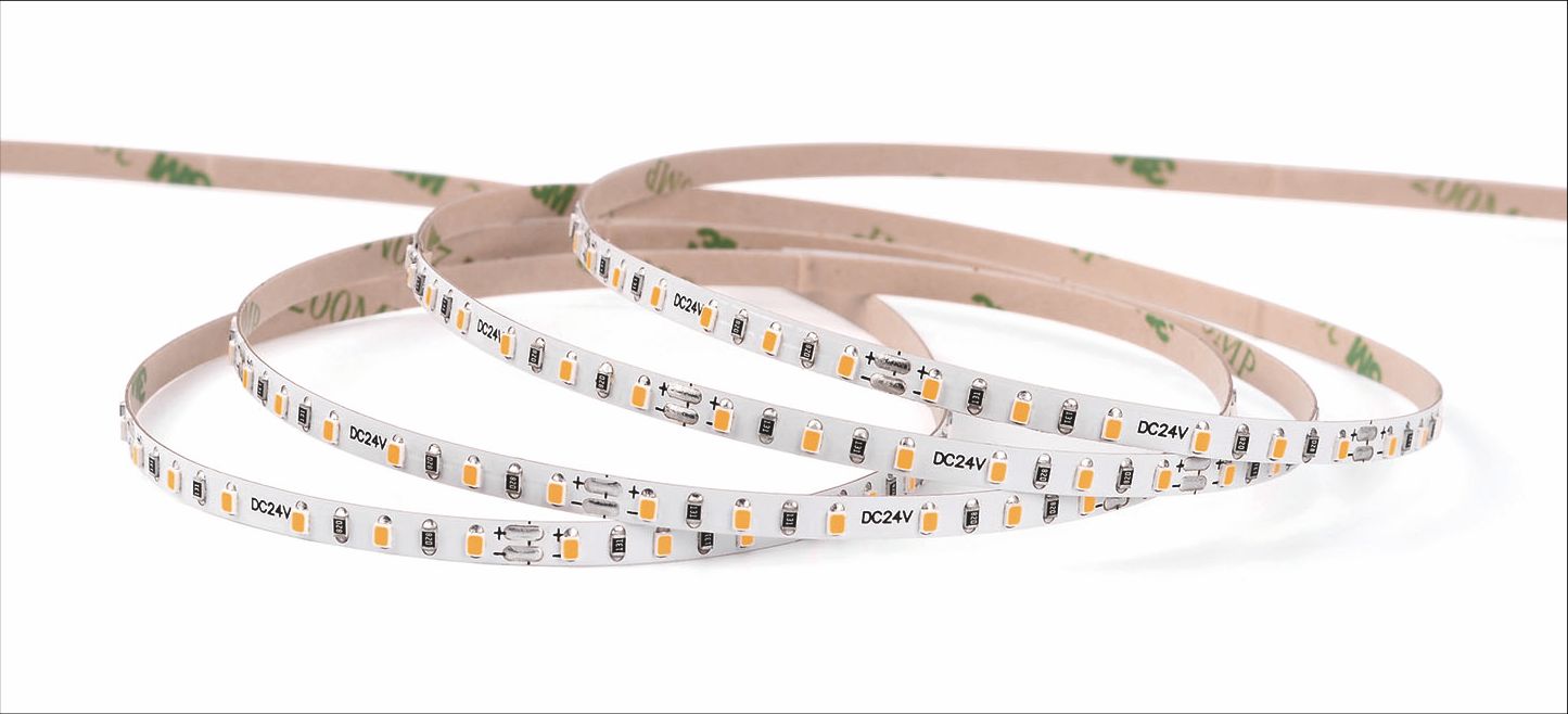 Flexible LED light strips with adhesive backing, coiled on a white surface.