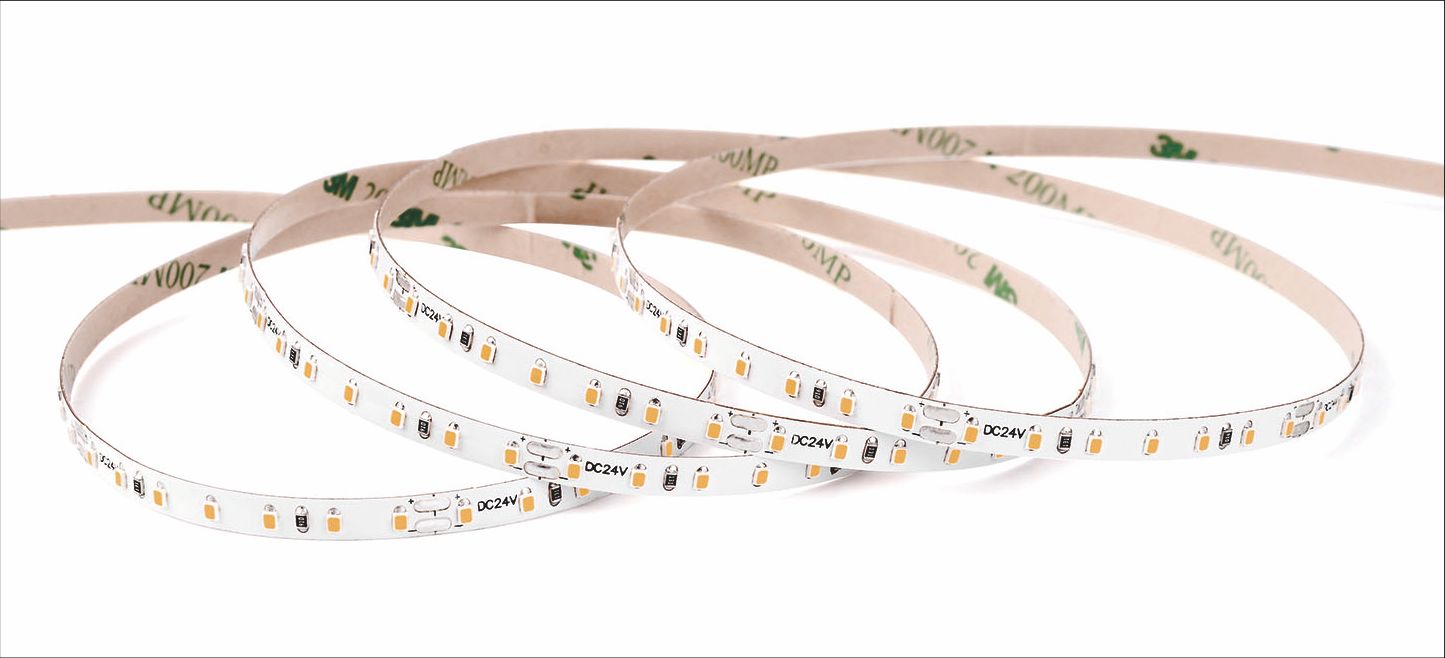 LED light strip with adhesive backing, coiled on a white surface.