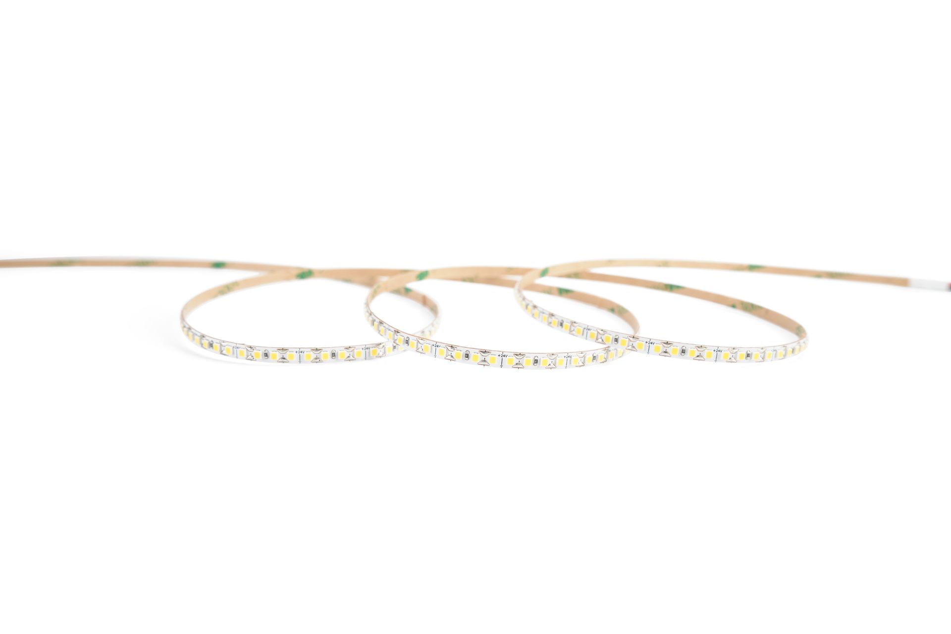 Flexible LED light strip, tan with evenly spaced white lights, coiled on white background.