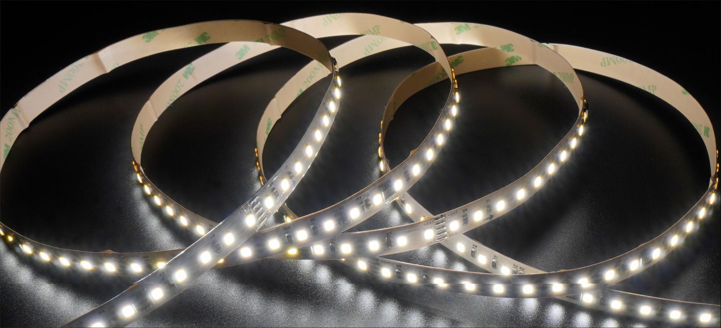 LED light strips coiled on a dark surface, emitting bright white light.