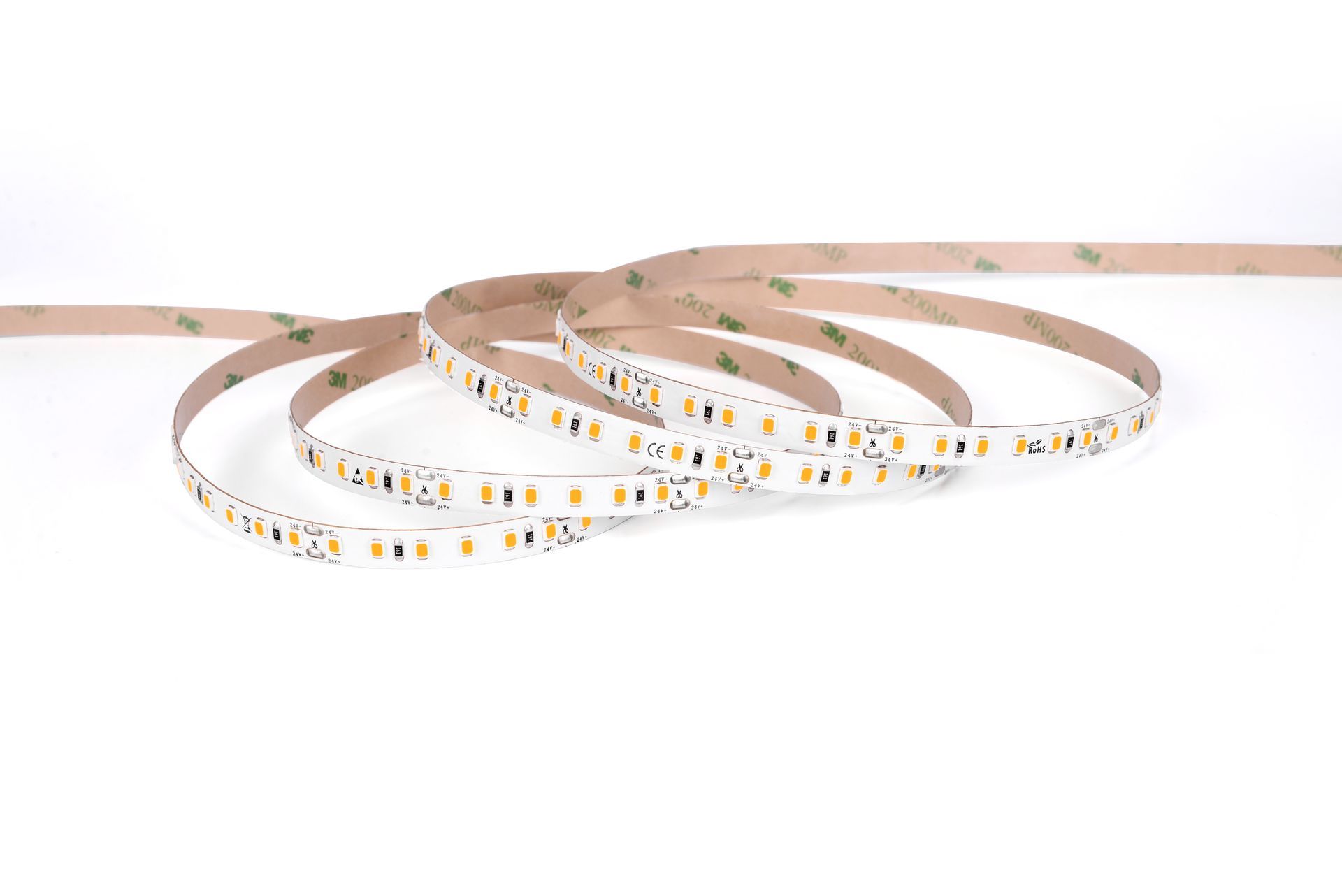 LED light strip coiled on a white surface, with adhesive backing exposed.