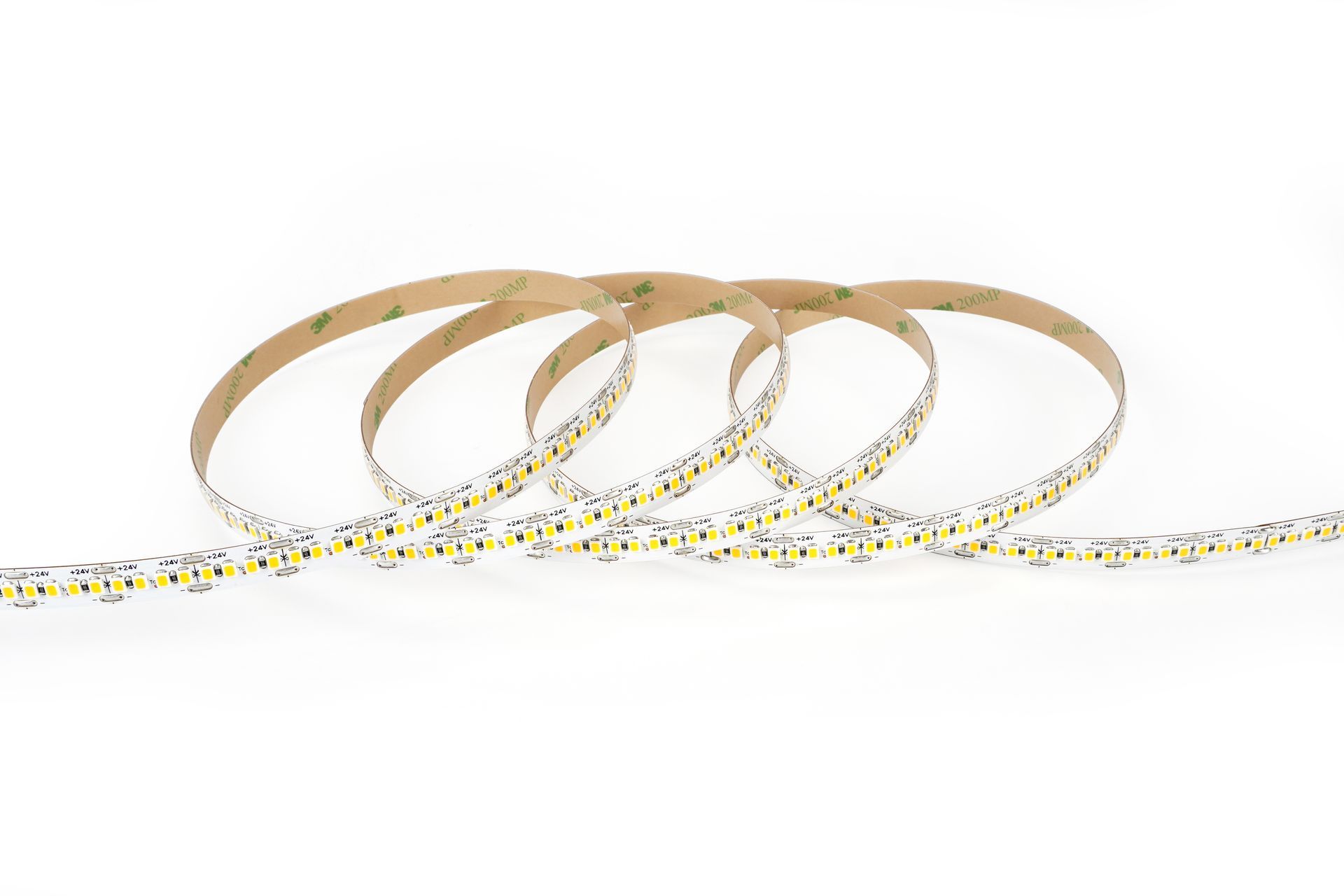 LED strip lights coiled on a white surface, showing the adhesive backing.