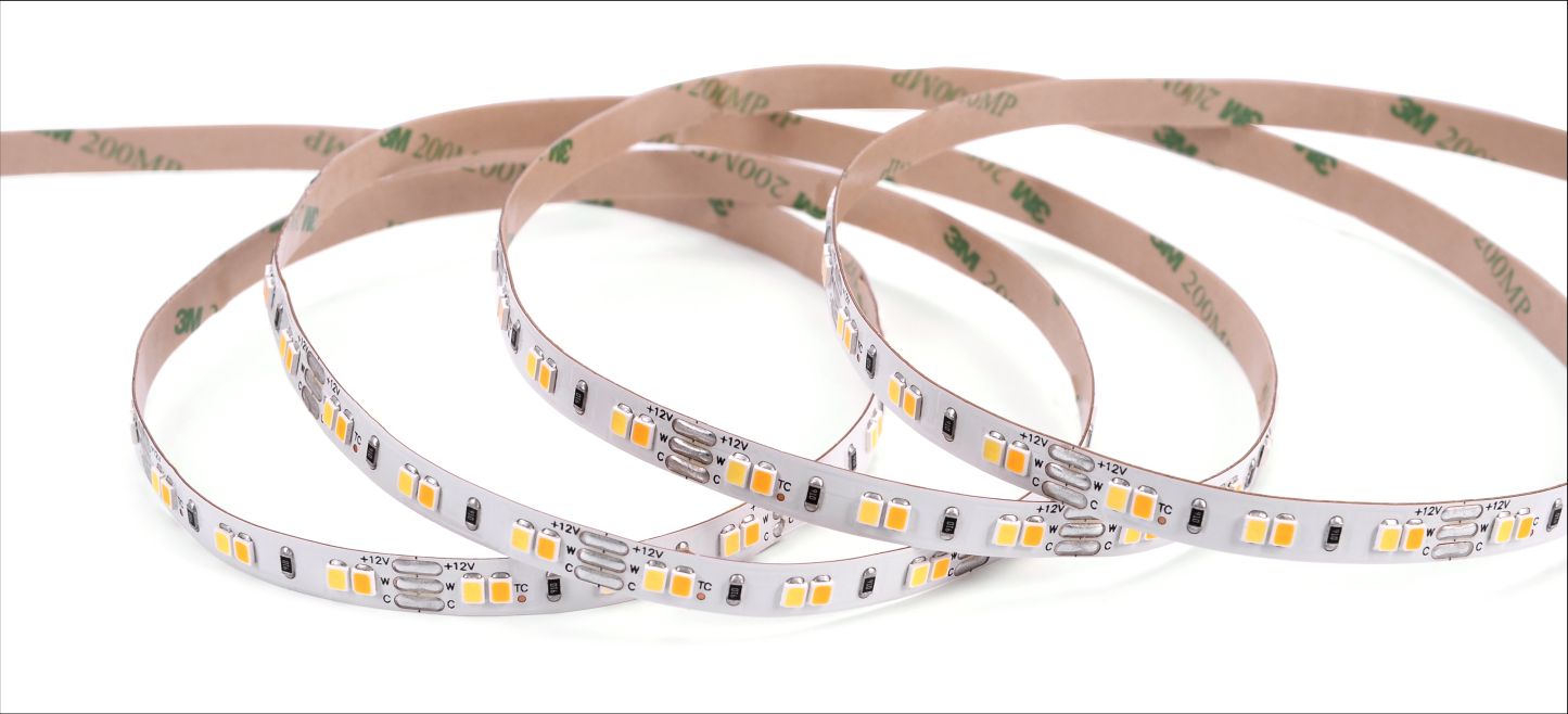 LED light strip coiled, with visible LEDs. Backing with adhesive. White background.
