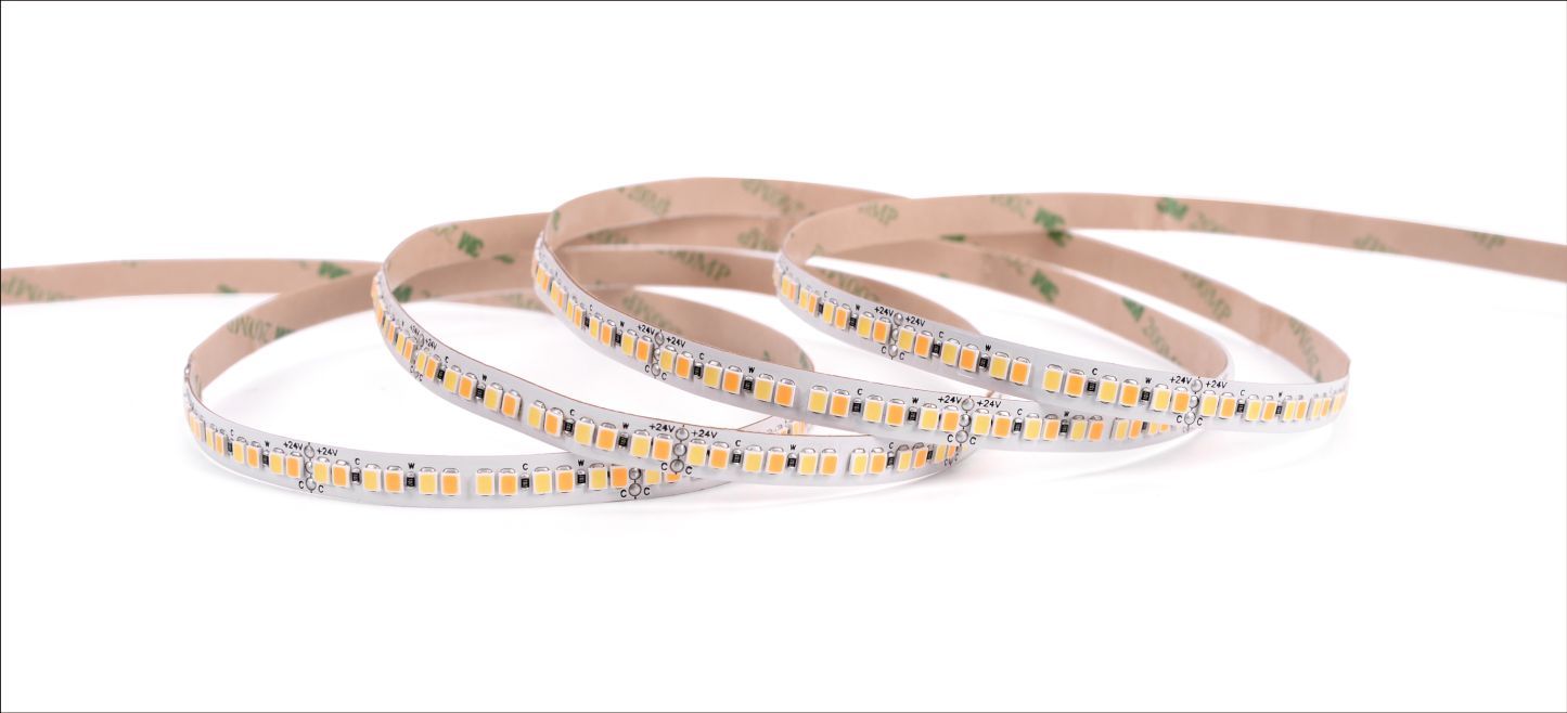 A flexible LED light strip coiled on a white surface, showing individual LEDs and adhesive backing.