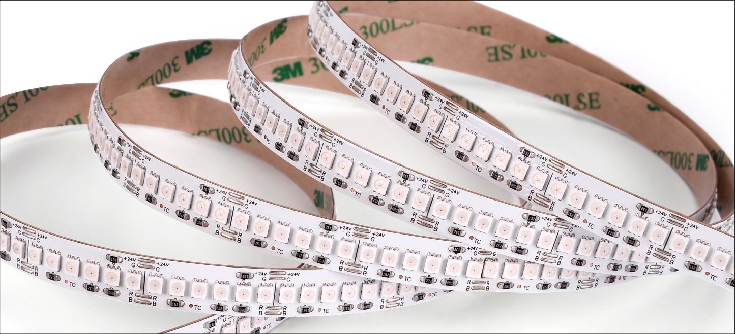 Flexible LED strip with adhesive backing, coiled on a white surface.