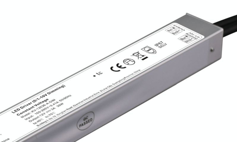 Silver LED driver with label showing specifications and certifications, with a black power cable.