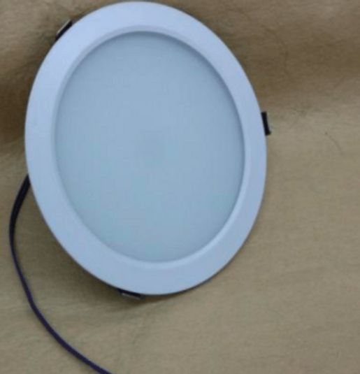 Round white recessed LED ceiling light with attached wires.