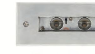 Close-up of a silver light fixture with two circular bulbs and a black arrow pointing to the right.
