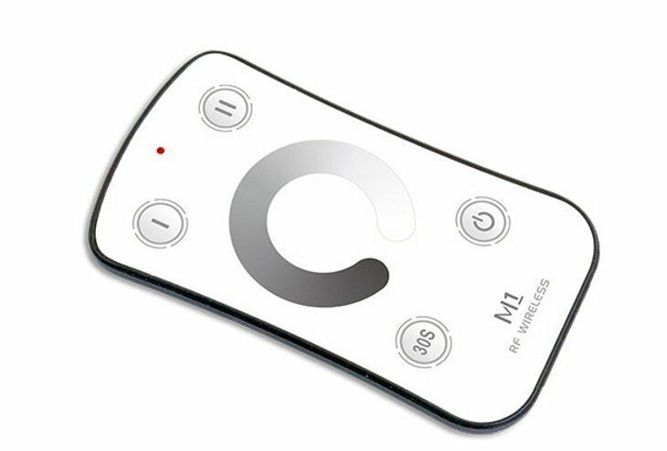 White remote control with a circular brightness dial and power button; red LED lit.