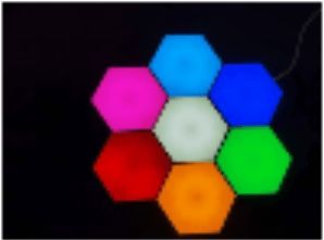 Seven colorful hexagon-shaped LED lights arranged in a flower-like pattern against a black background.