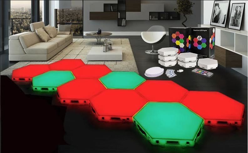 Hexagonal LED light panels on a floor, lit in red and green, in a living room setting.