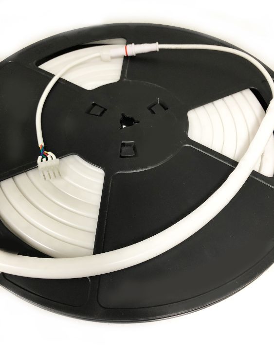 Black spool of LED strip lighting, white cable attached.