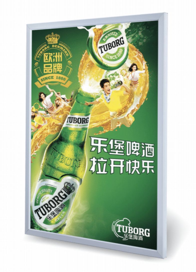 Tuborg beer advertisement: A green bottle sprays beer with a cheerful family, green background.