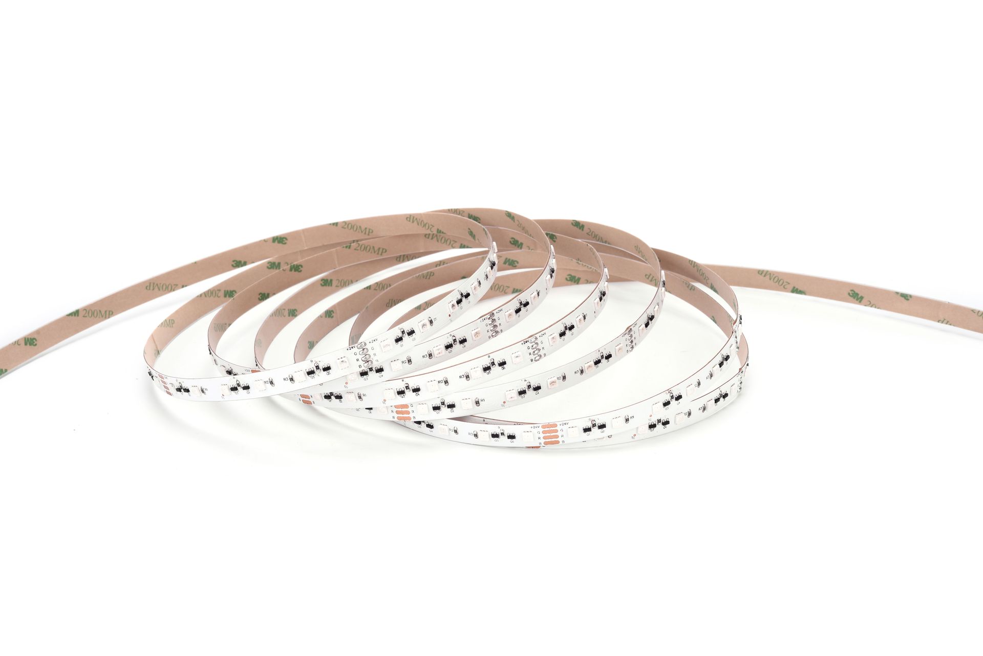 LED light strip with adhesive backing, coiled on a white surface.