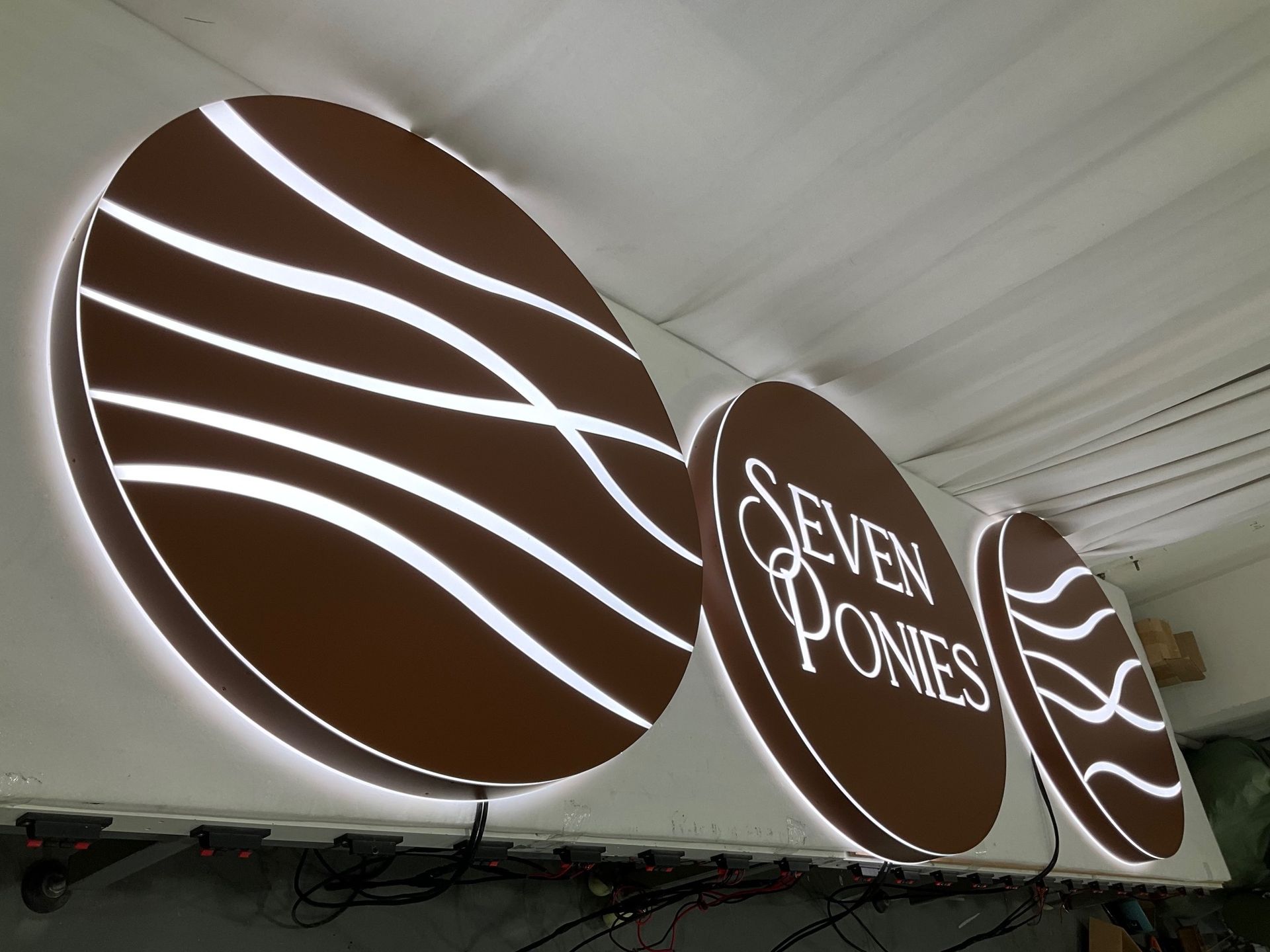 A Halo Lit Sign That Says Seven Ponies