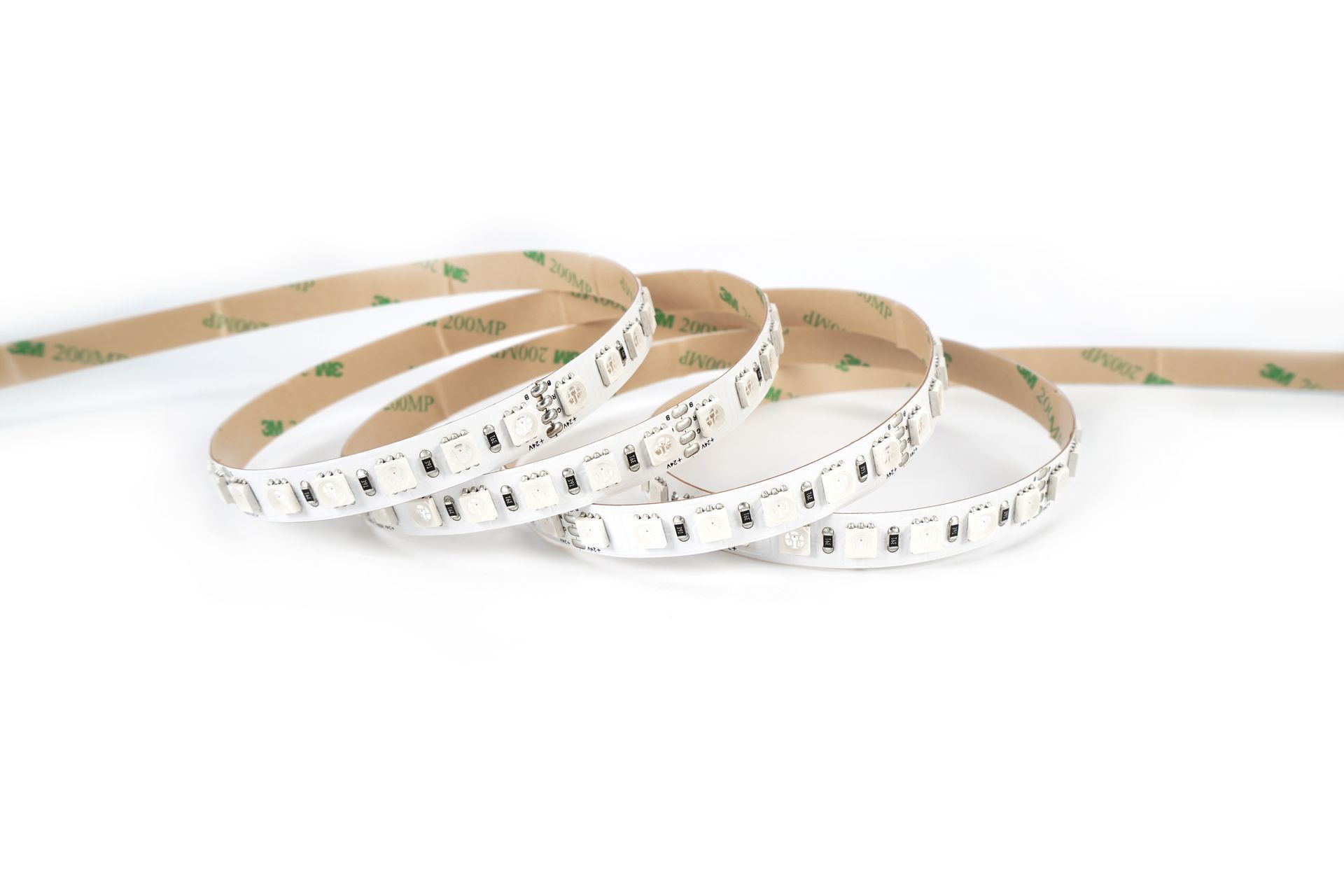 LED strip light, white with adhesive backing, coiled on a white surface.