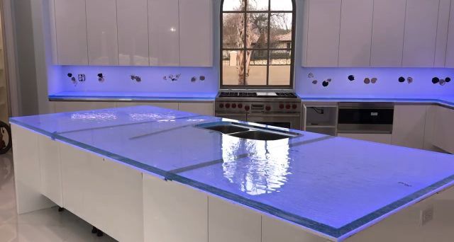 A kitchen with a blue counter top and white cabinets.