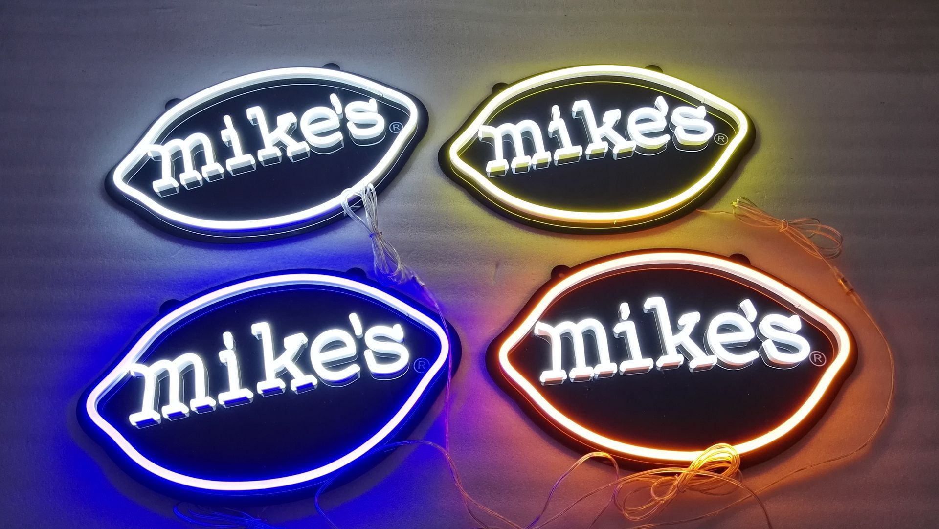 Four mike 's neon signs are lit up in different colors