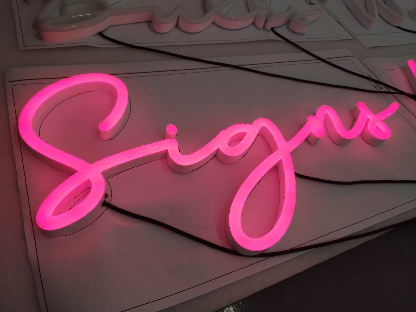 Neon Sign that says Sign's in Cursive