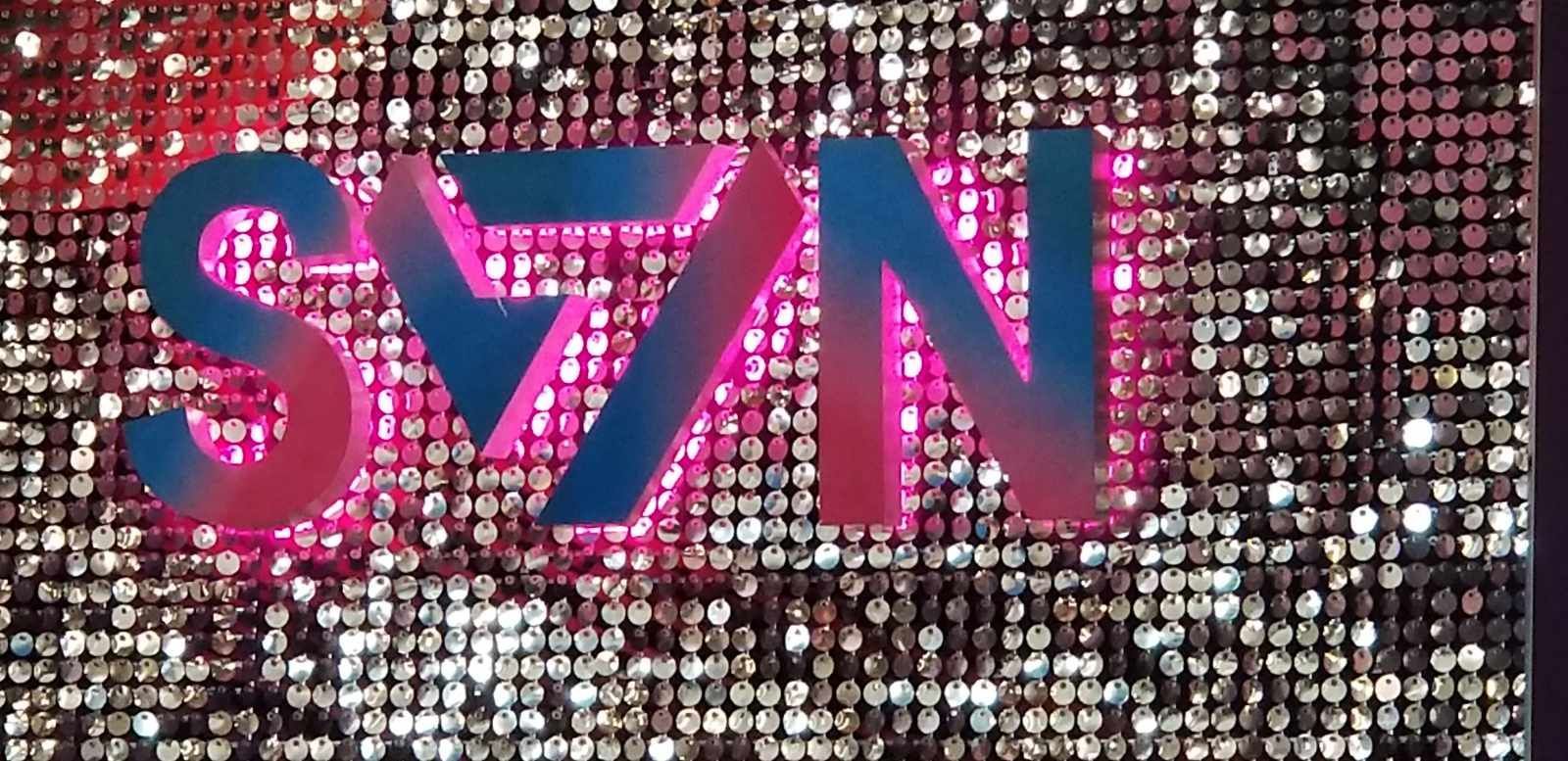 A pink and blue sign with the word syn on it