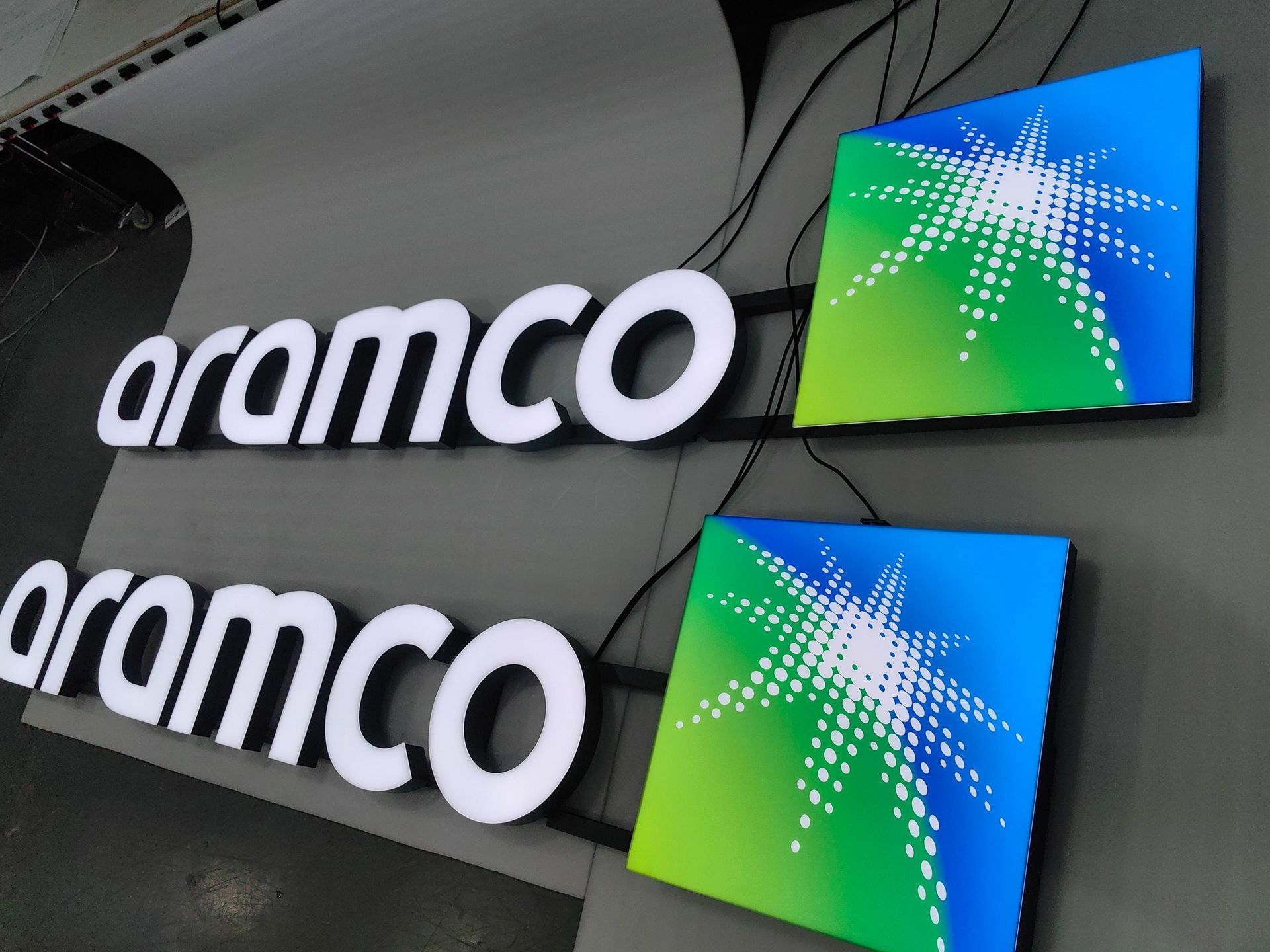 Two aramco signs are hanging on a wall