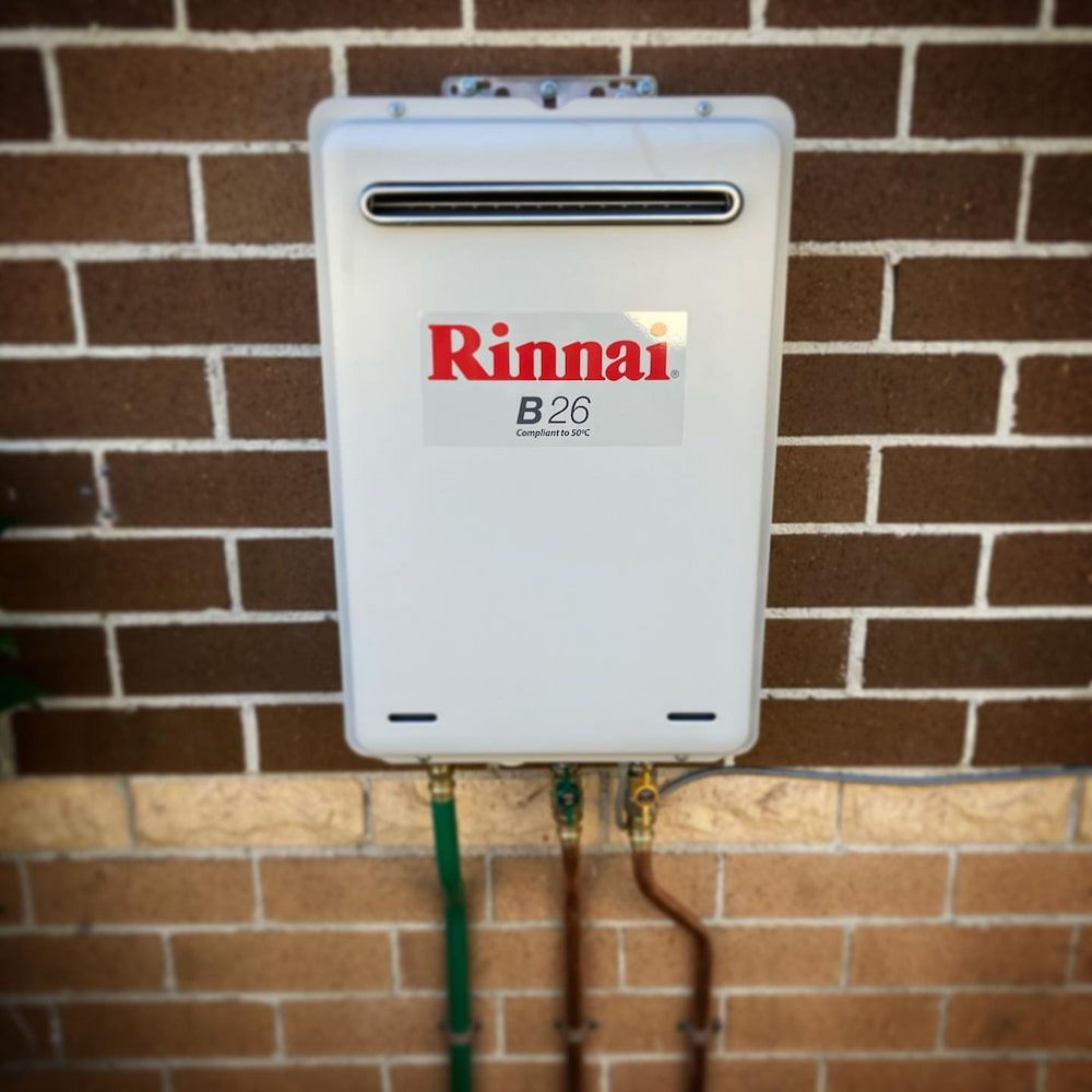 Rinnai B26 Tankless Water Heater Mounted on a Brick Wall — Corrimal Plumbing Services in Bulli, NSW
