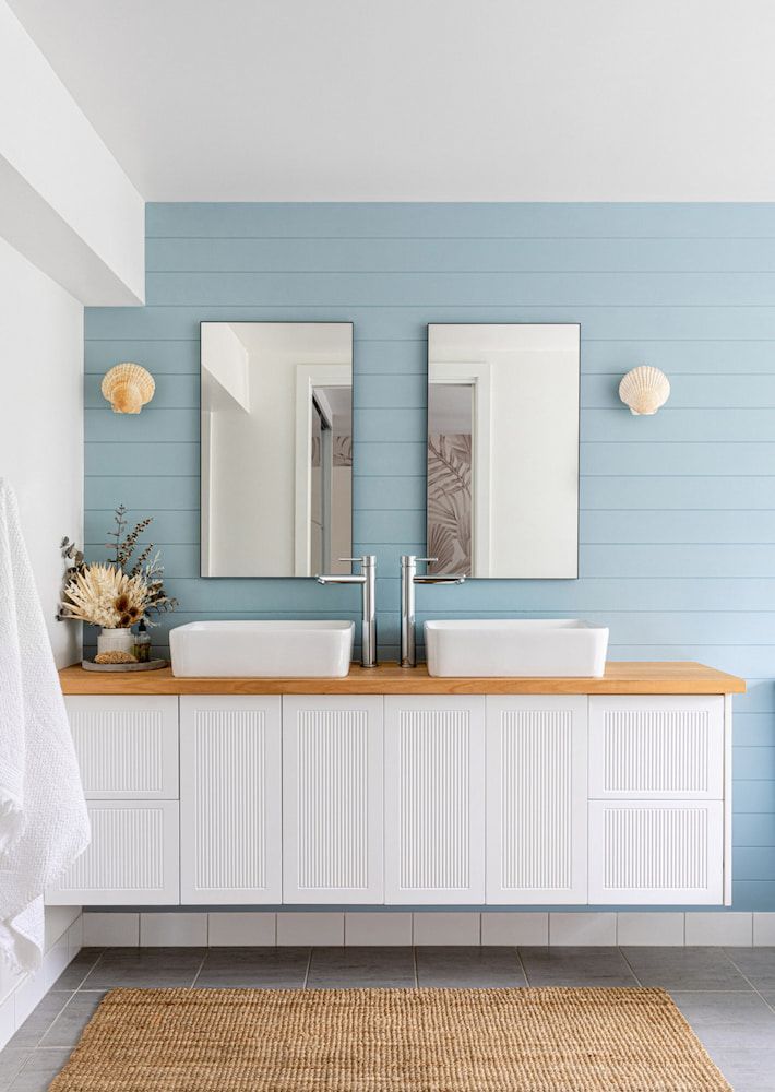 Bathroom With Blue Shiplap Walls, White Floating Vanity and Two Mirrors — Corrimal Plumbing Services in East Corrimal, NSW