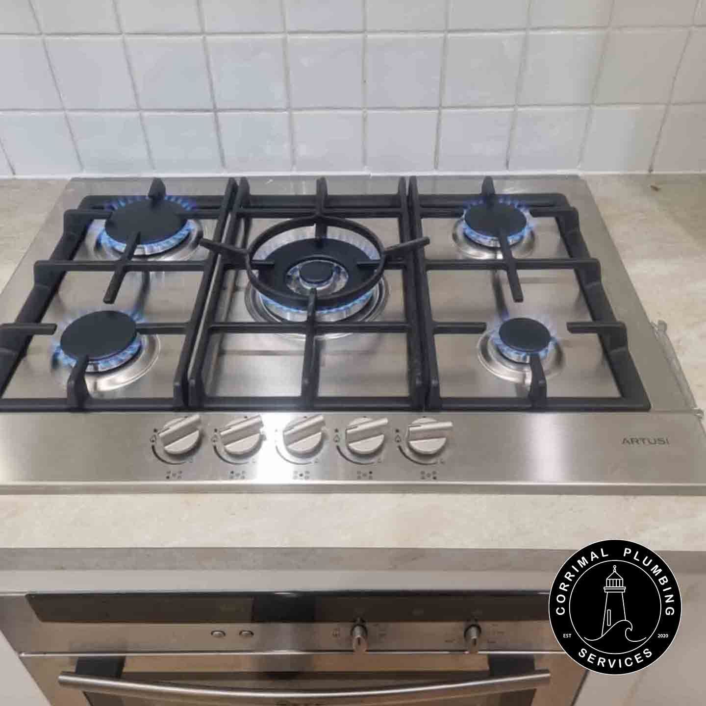Stainless Steel Gas Cooktop With Blue Flames — Corrimal Plumbing Services in East Corrimal, NSW