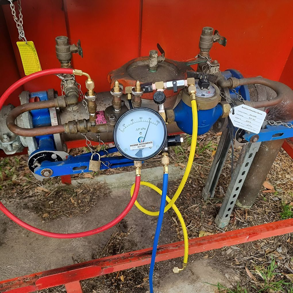 Blue And Red Hoses Connected To A Pressure Gauge — Corrimal Plumbing Services in Bulli, NSW