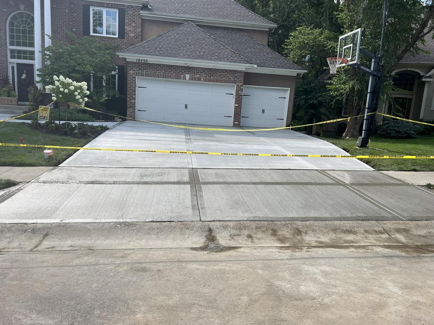A man is pouring concrete into a wooden frame.